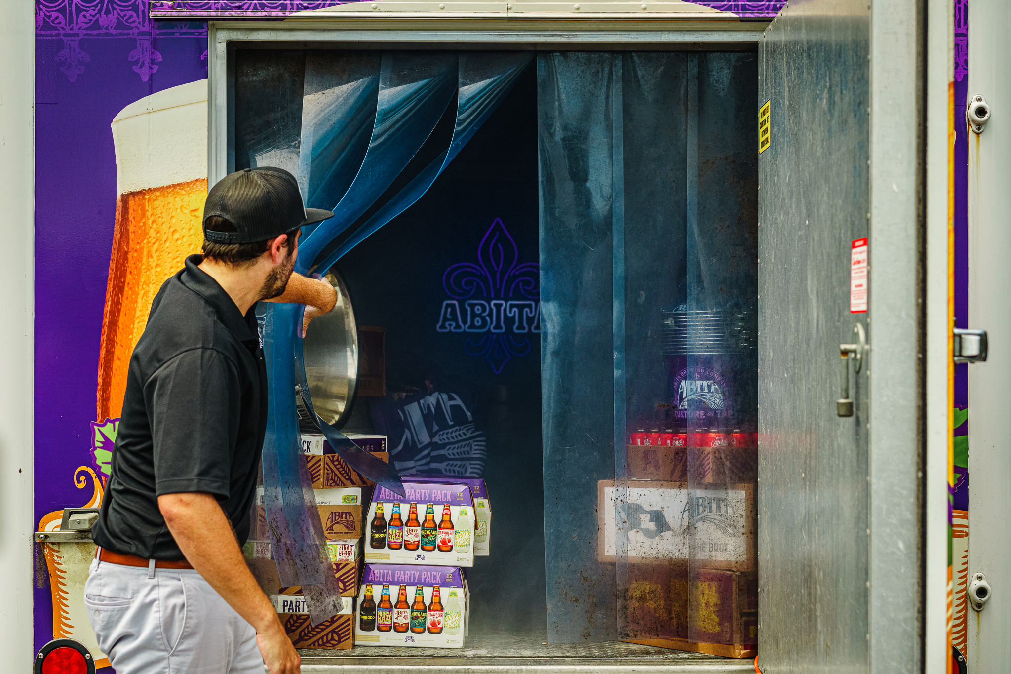 man looking into abita beer trailer with stacks of abita beer inside