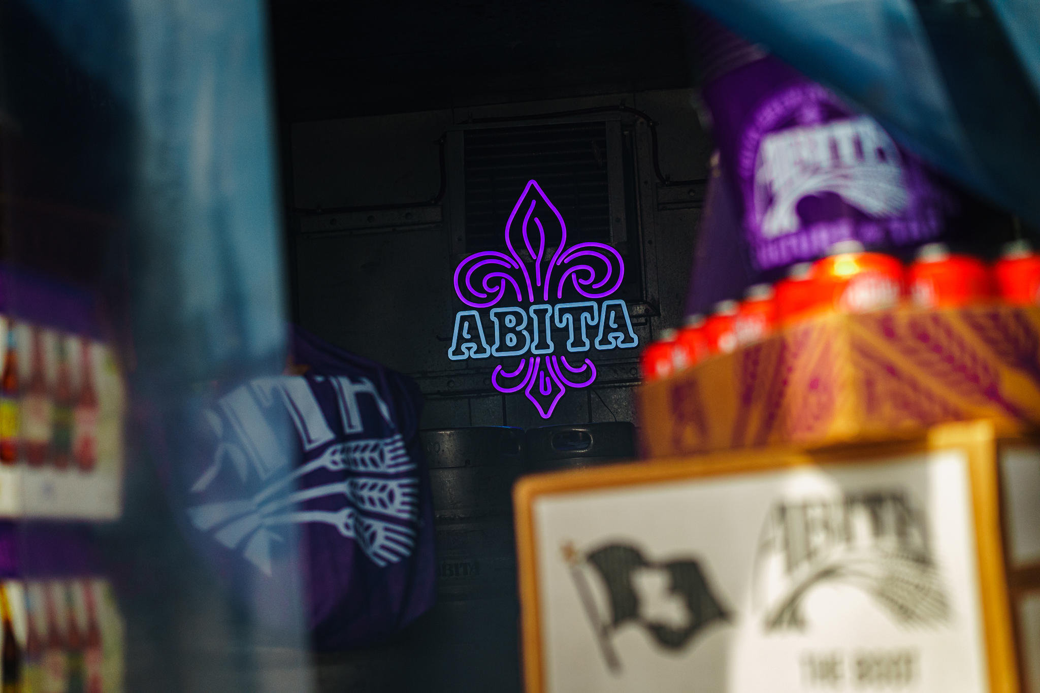 abita neon sign surrounded by cases of beer