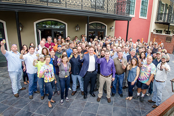 all abita employees toasting with a beer in the taproom patio