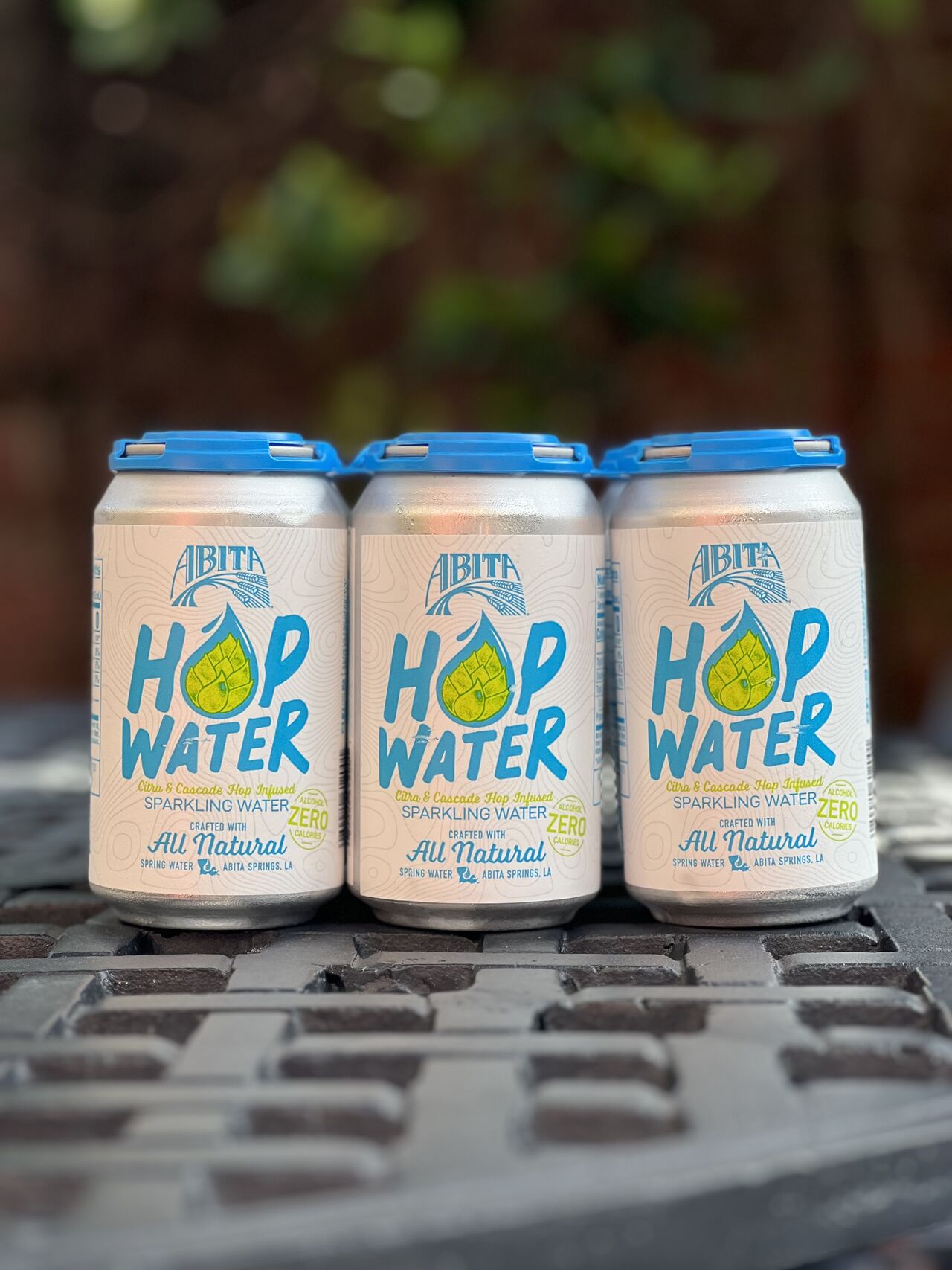 6pk of hop water on iron table outside