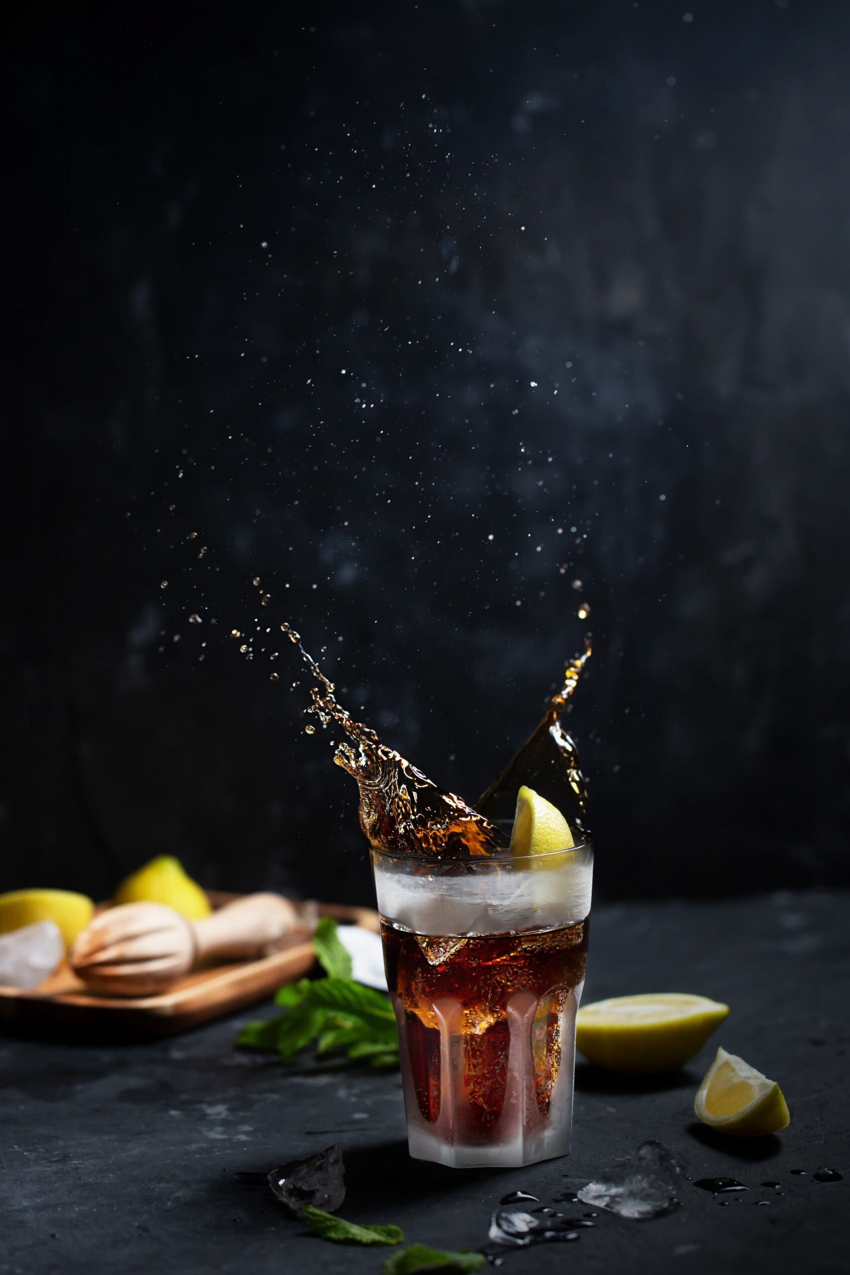 a flavored malt beverage in a clear glass with a lemon slide in it