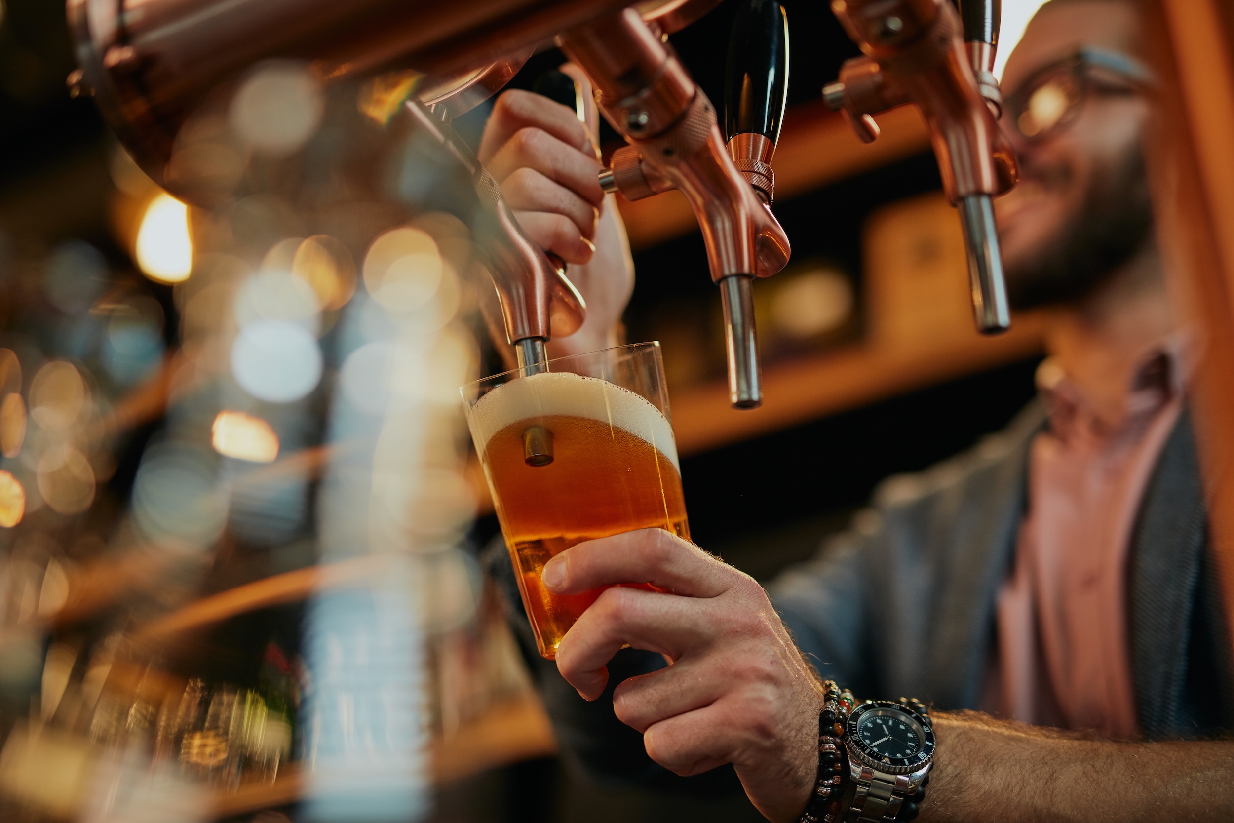 pasteurized beer being poured into a glass from on tap