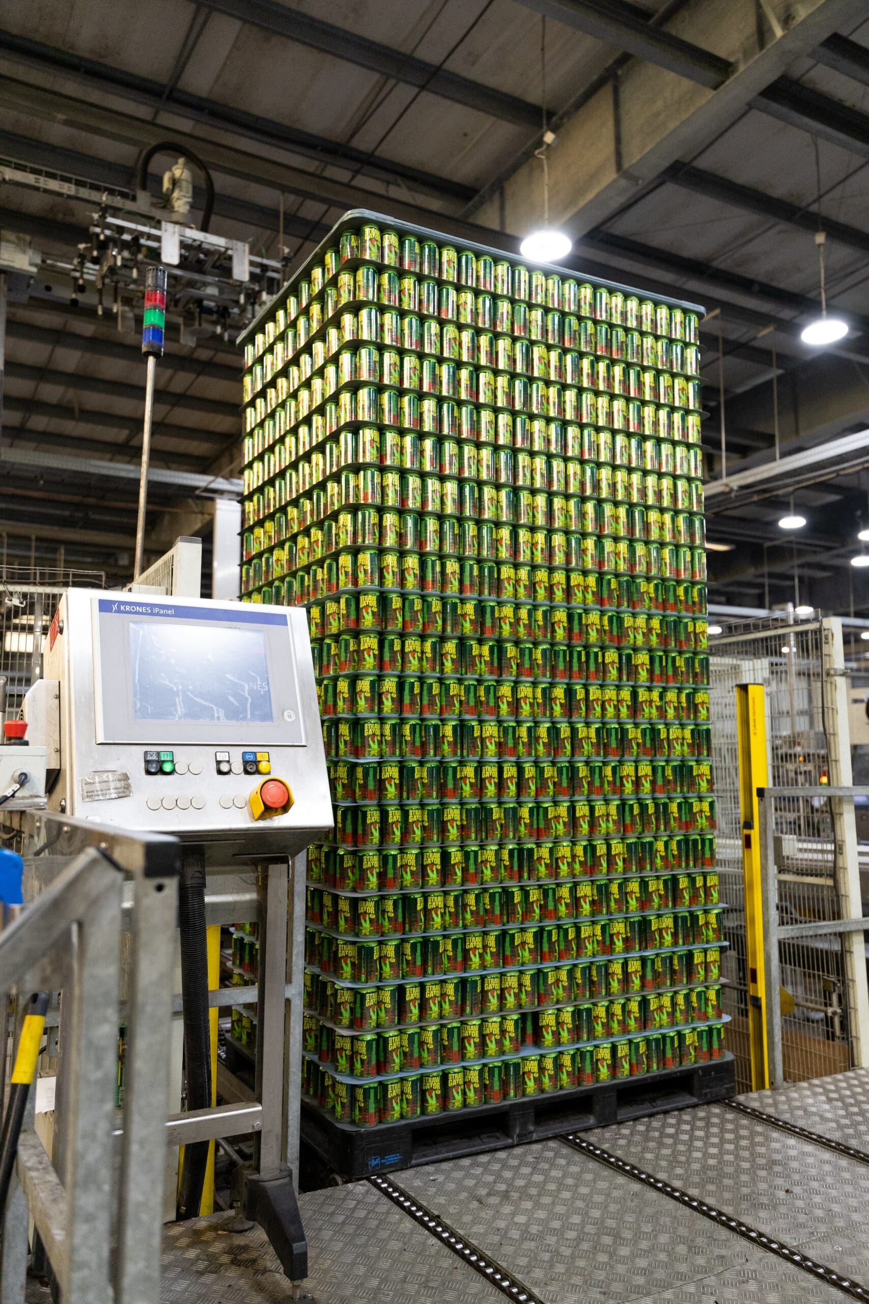 green cans of beer stacked high in a beverage warehousing management facility