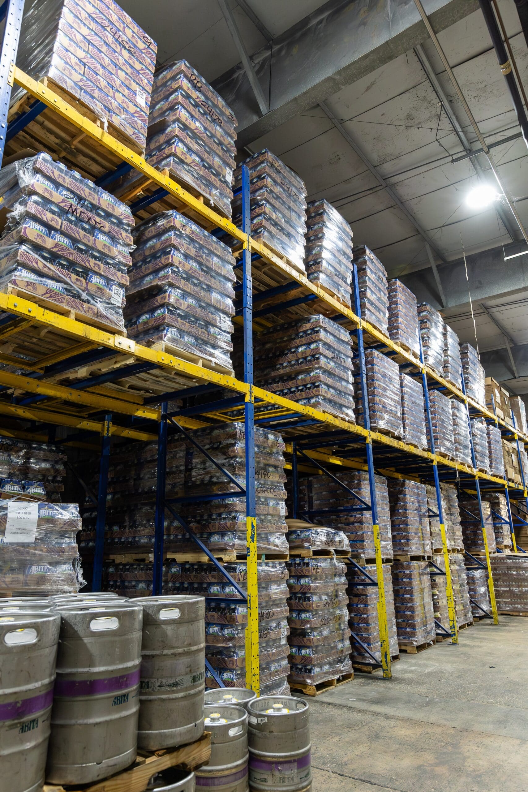 pallets of beer stacked on shelves in a beverage warehousing management facility
