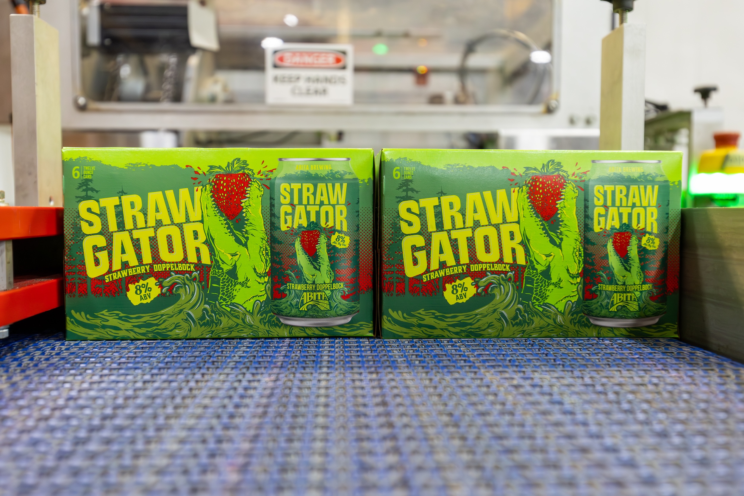 boxes of canned beer making its way down a conveyor belt in an open brewery facility
