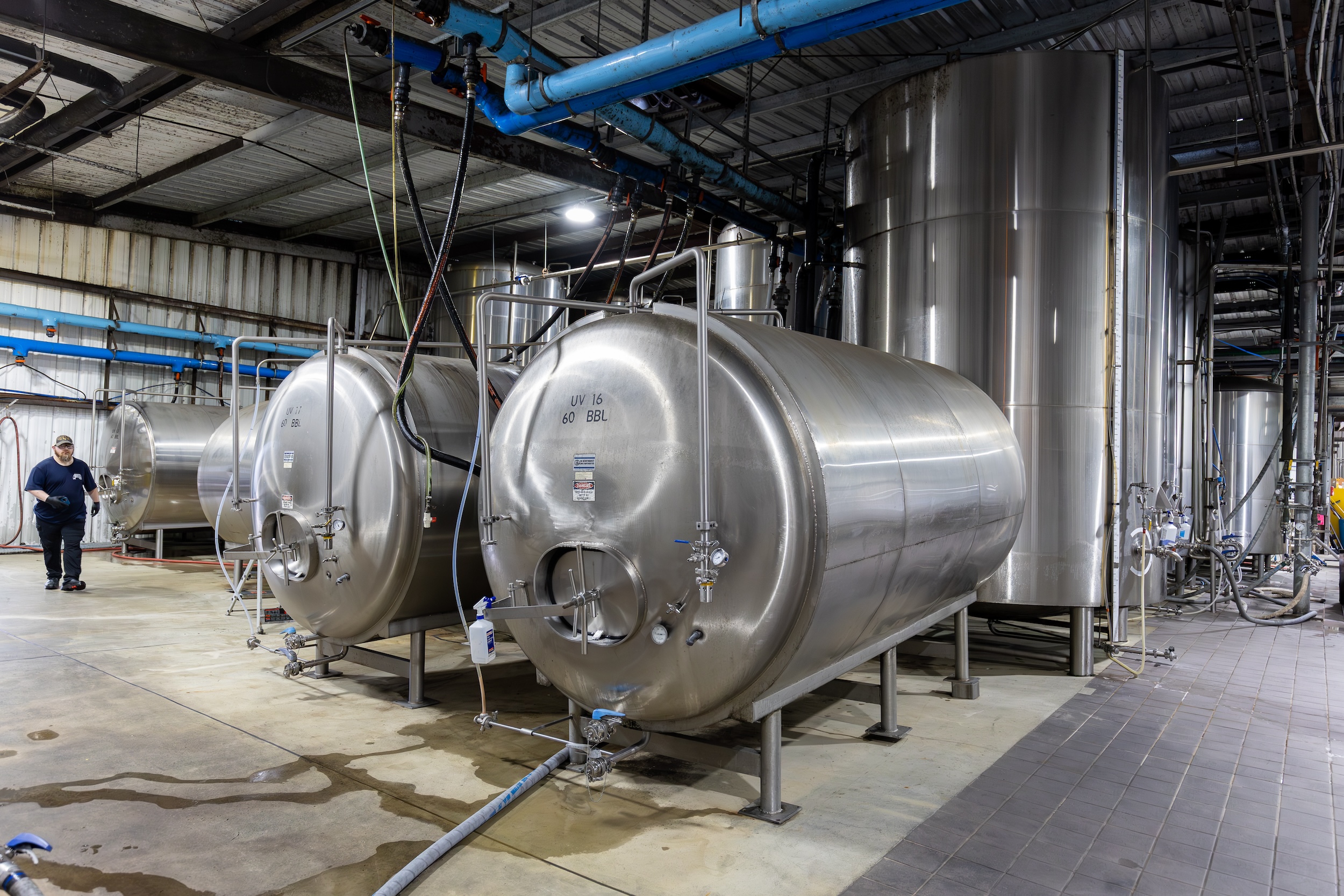 stainless steel brewery equipment in an open warehouse brewing facility