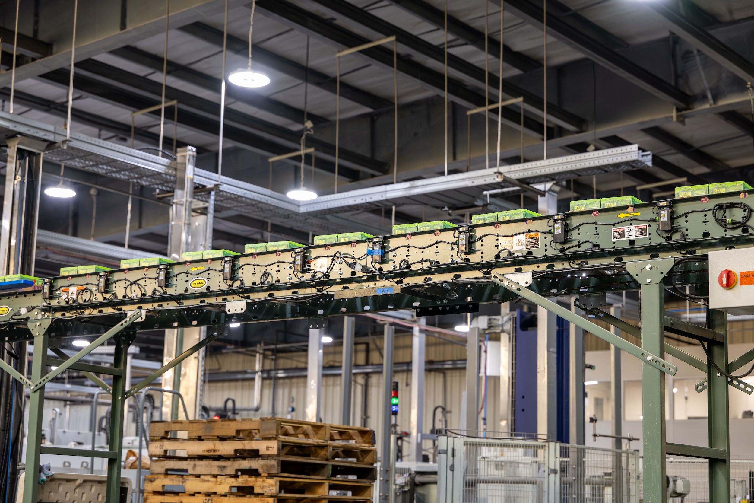 boxes of beer making their way along a conveyor belt in a brewery warehouse facility